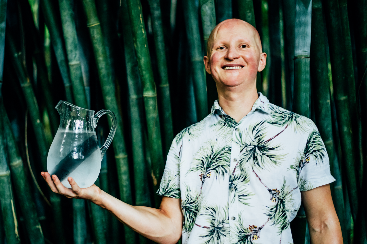 Natural Filters founder, Igor Pershin holding a water jug with a charcoal filter